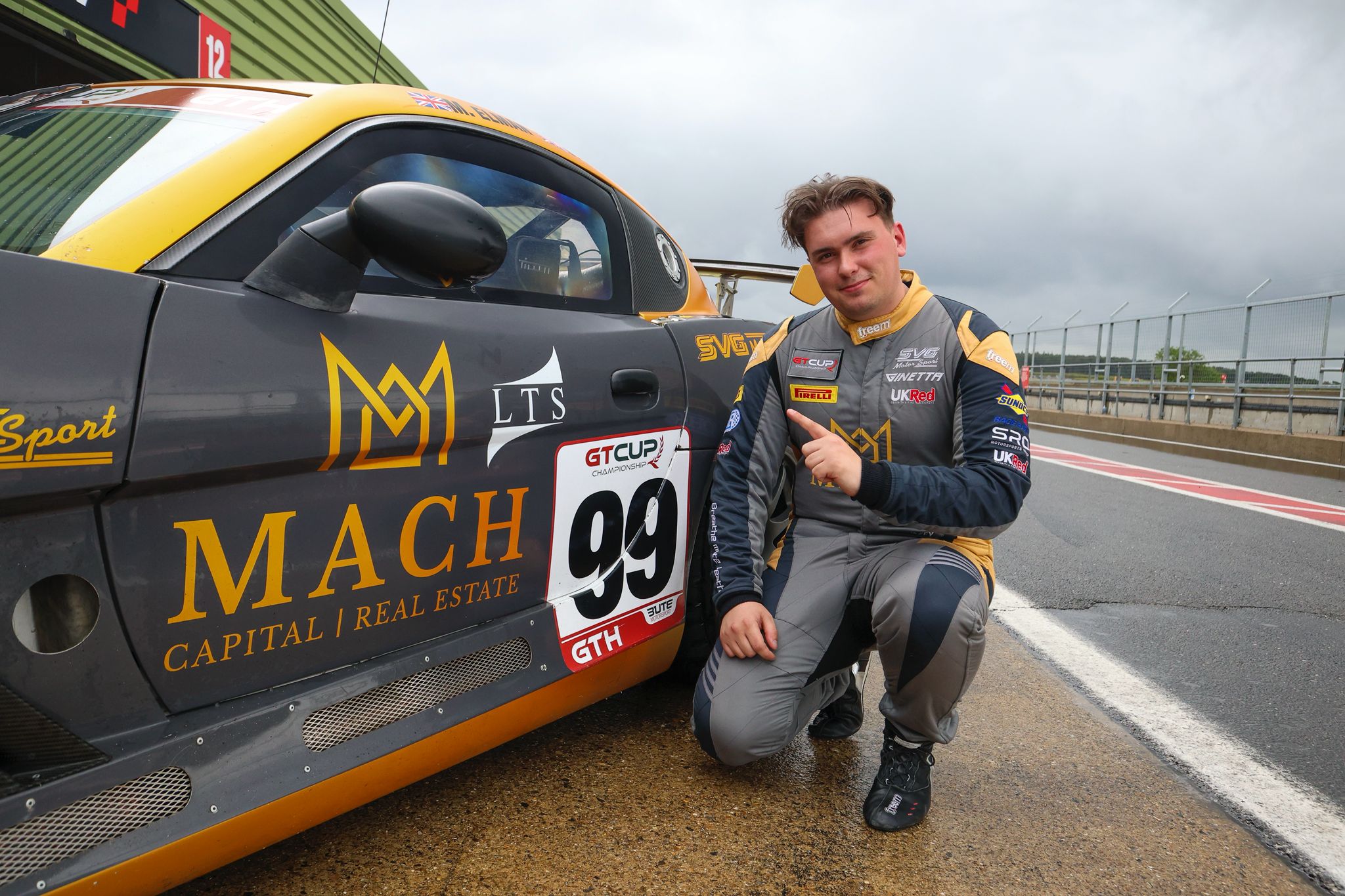 Owen Hizzey beside the number 99 racing car